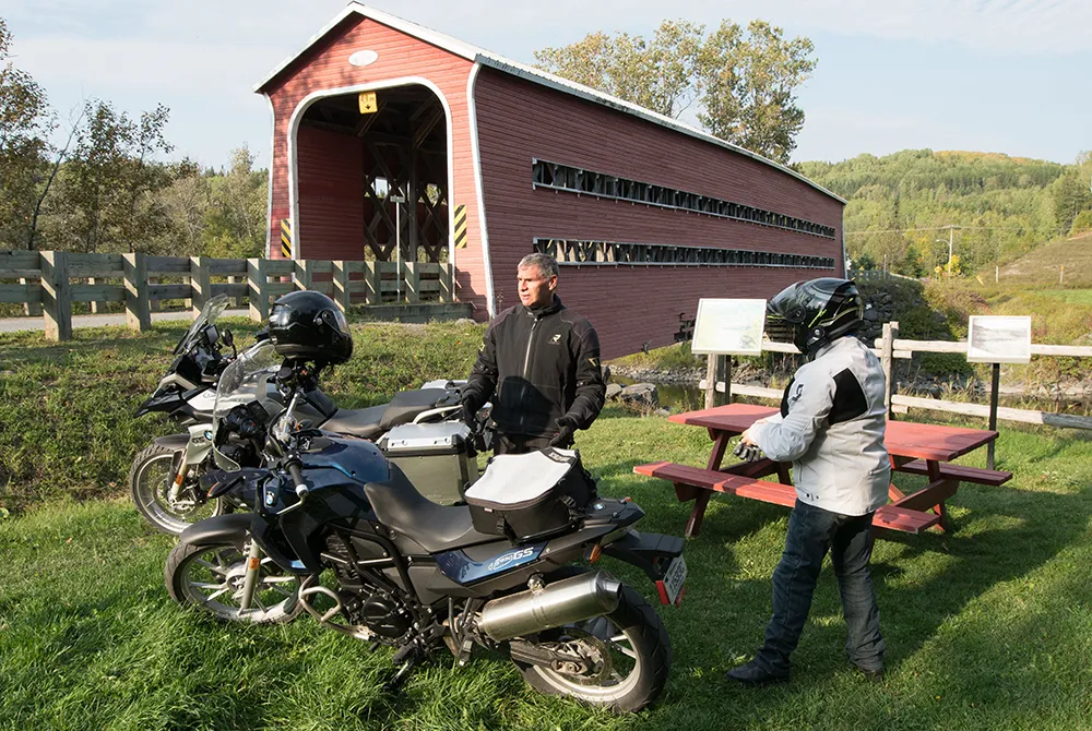 Motocyclistes devant pont couvert